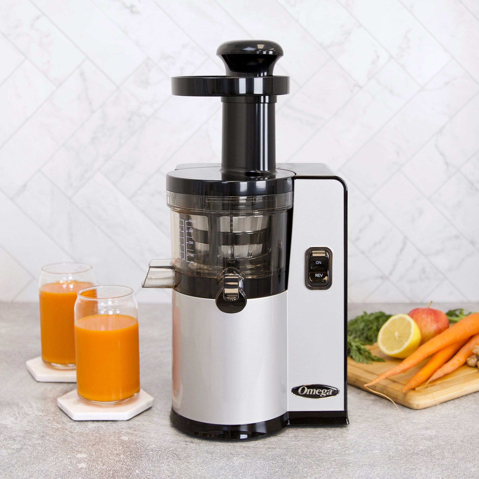 Silver Omega VSJ843Q vertical slow juicer with its feed tube, screen bowl, reverse control and juice tap